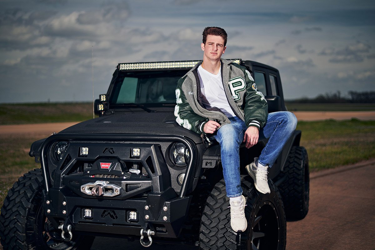 prosper senior photographer boy sitting on jeep in letterman jacket